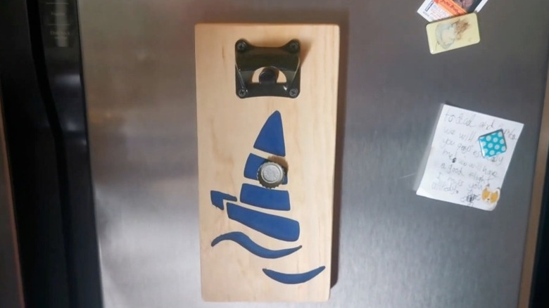 Hanging bottle opener with magnetic cap catcher