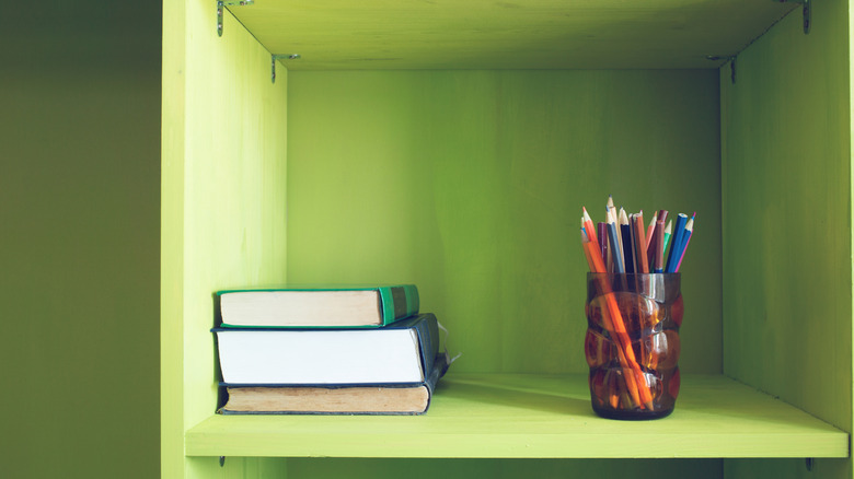 cup of pens on a shelf