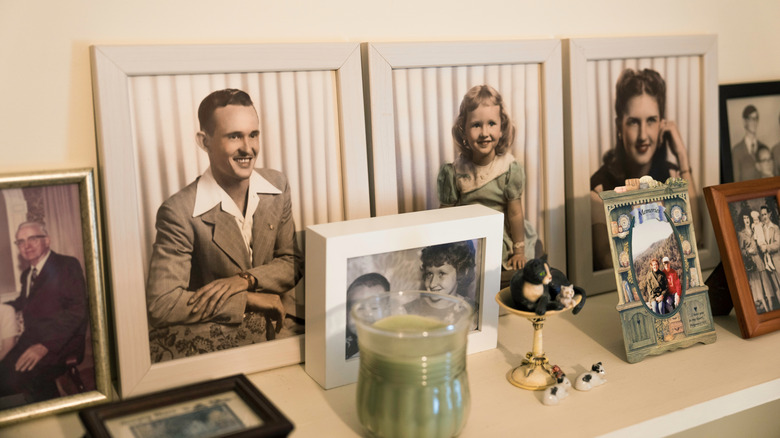 Many framed old family photos on shelf