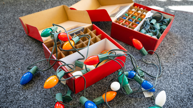Boxes of Christmas lights on a grey carpet