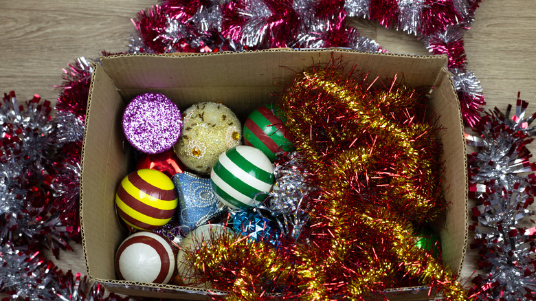 Tinsel garland and ornaments in a cardboard box