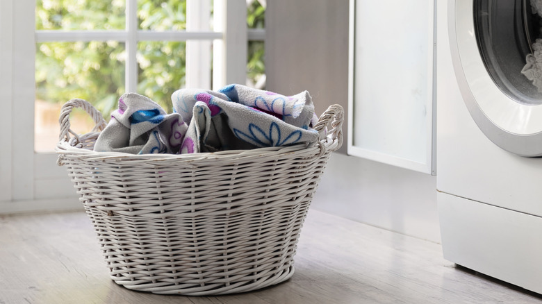 Basket of dirty laundry near a washing machine