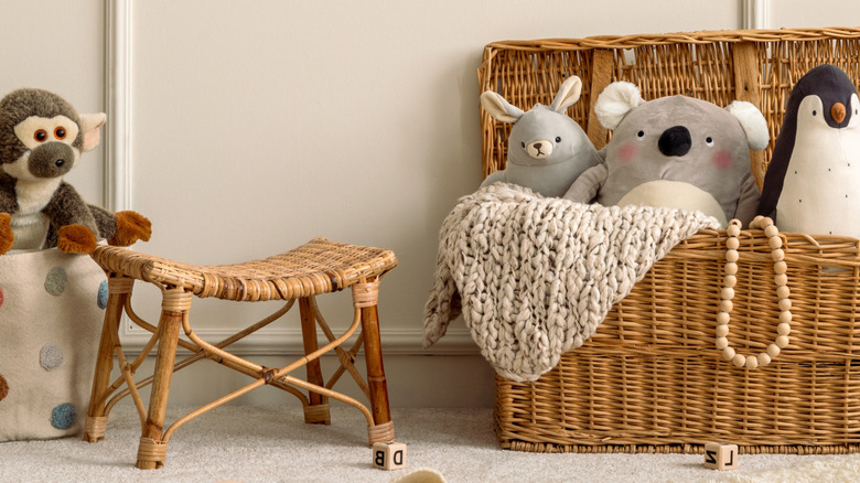 Stuffed toys in a wicker picnic basket and a wicker stool