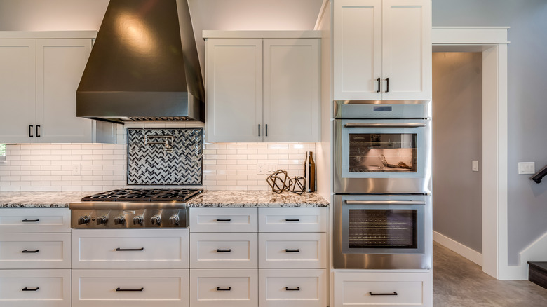 A double-wall oven installed into a tall cabinet in a modern kitchen.