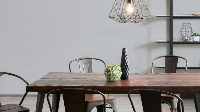 Industrial dining room with a wooden table and metal chairs with a metal pendant light.