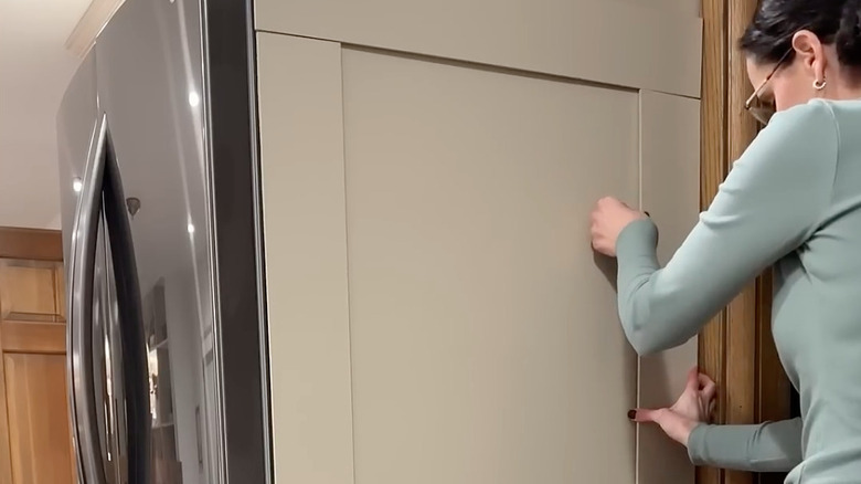 Woman covering painted fridge with magnetic boards
