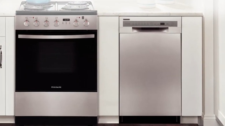 A silver Frigidaire dishwasher near a gas range from the brand