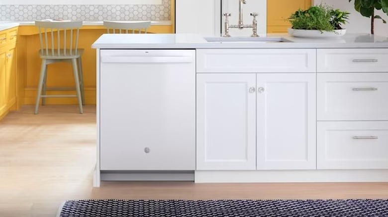 A white dishwasher installed near on one end of a kitchen island