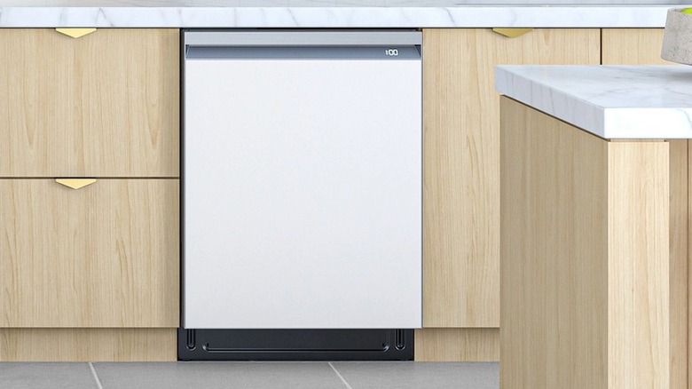 A white-colored dishwasher in a kitchen with wood drawers