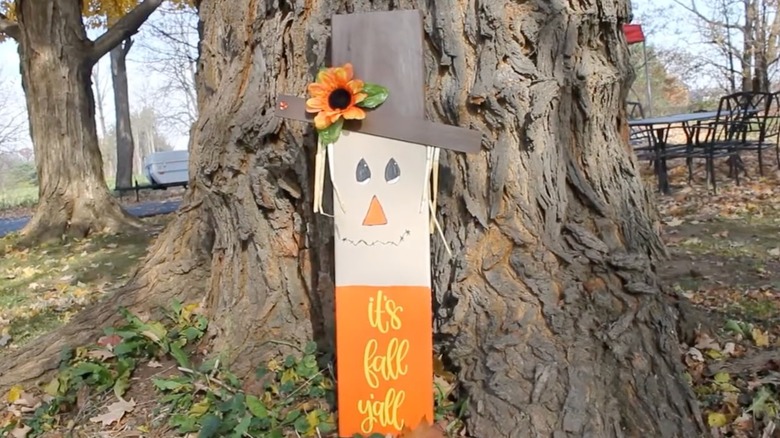 Scarecrow sign that reads "it's fall y'all"