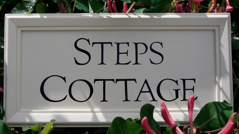 A white framed sign "STEPS COTTAGE"