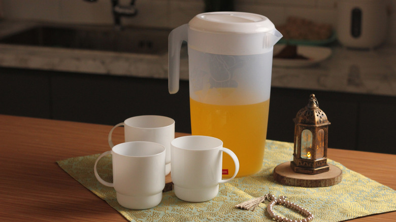 Plastic pitcher and cups with juice