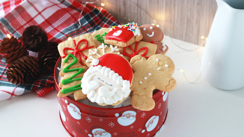 A Santa-themed holiday tin filled with cookies.