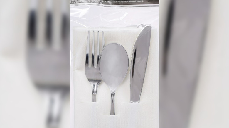 A close-up of plastic cutlery in a napkin.