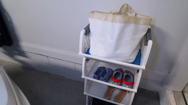 White plastic containers stacked on top of one another to make a shoe and bag rack.