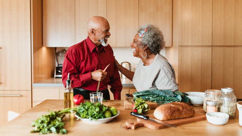 older couple laughing together in their kitchen