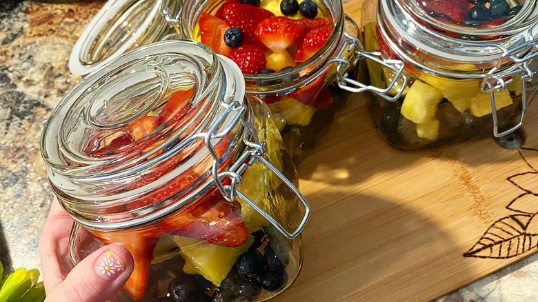 square glass jars holding fruit
