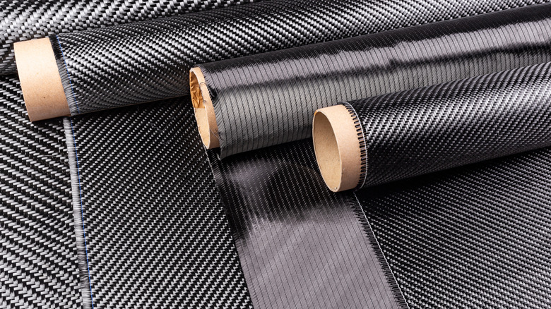 Rolls of various woven carbon fiber cloths.