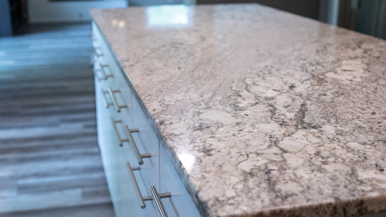 A gray granite countertop on a kitchen island.