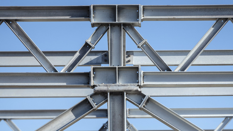 Steel construction beams against a blue sky.