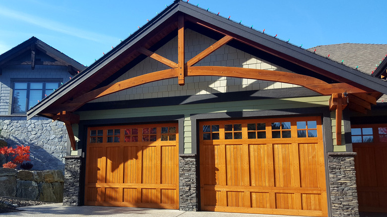 Gray stone house with orange wood garage doors
