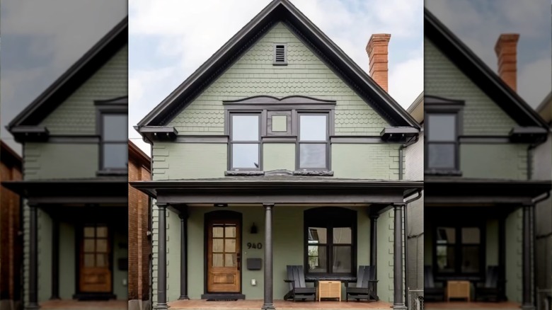 deep green home with black windows, trims, and pillars