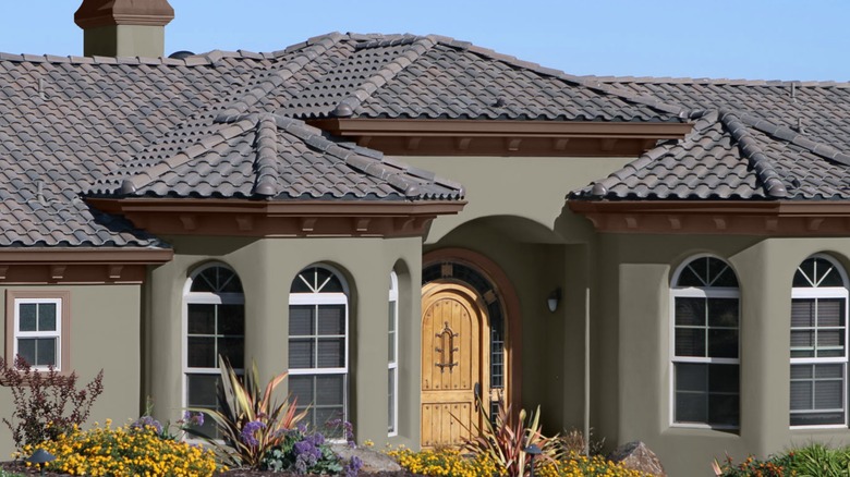 olive green house with yellow wooden front door