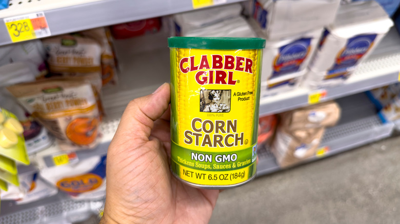 Person holding can of cornstarch in grocery store