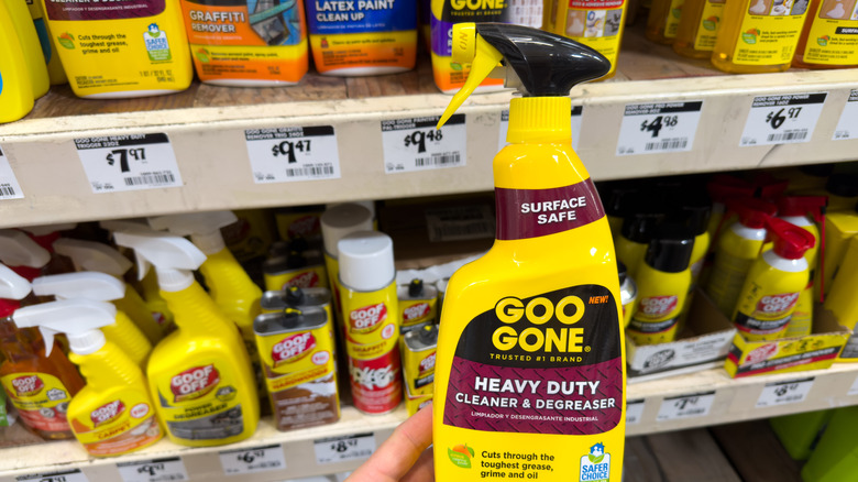 Closeup of person holding spray bottle of Goo Gone Cleaner & Degreaser at the store