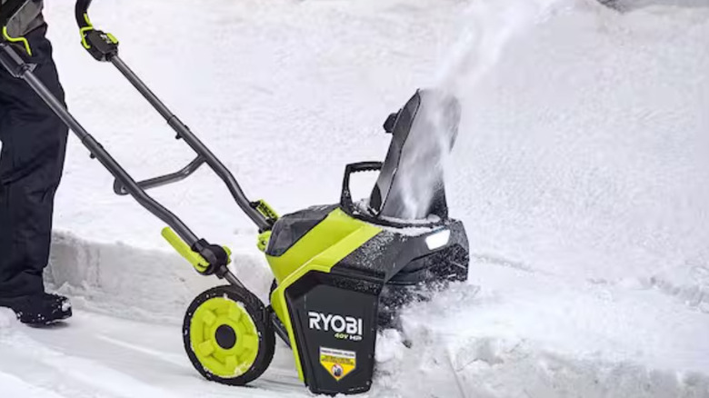 Customer pushing the Ryobi snow blower through thick snow.