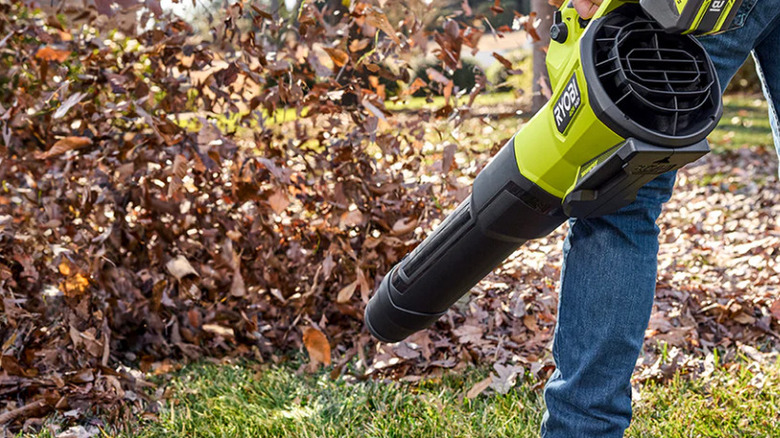 The Ryobi blower blowing a pile of dead leaves.
