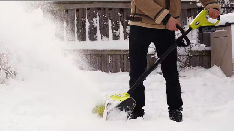 A man shoveling snow with the Ryobi electric snow shovel.