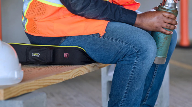 A worker sitting on the Ryobi heated cushion.