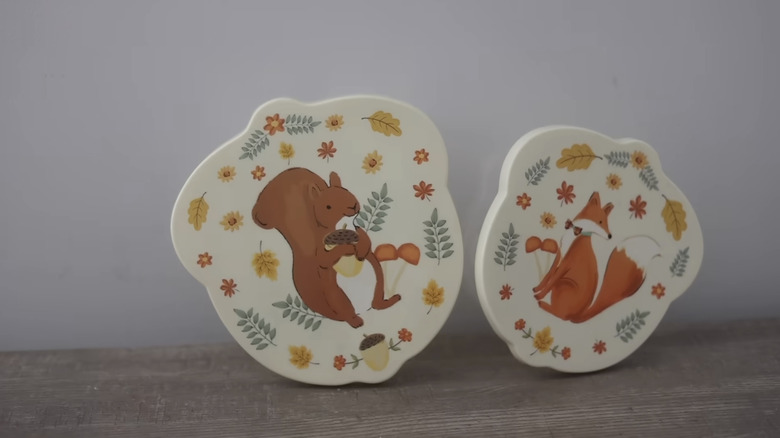 Two food containers with lids from Dollar Tree; one including an illustration of a squirrel with an acorn, and the other showing a fox