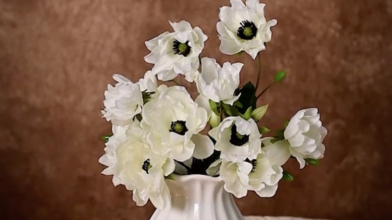 An arrangement of anemones against a brown background