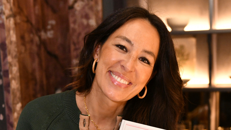 Smiling Joanna Gaines holding a book