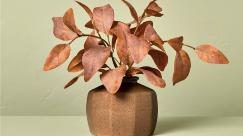Faux dried eucalyptus leaves in a copper vase