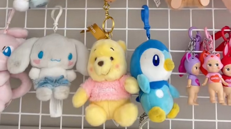 Plush keychains hanging from a wire tray