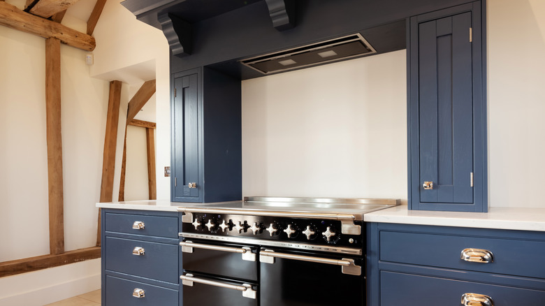 Oven range alcove painted dark blue with black stove
