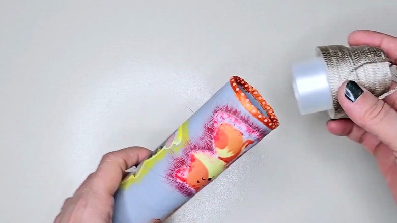 A pen and pencil holder made using detergent caps and a cardboard paper towel roll.