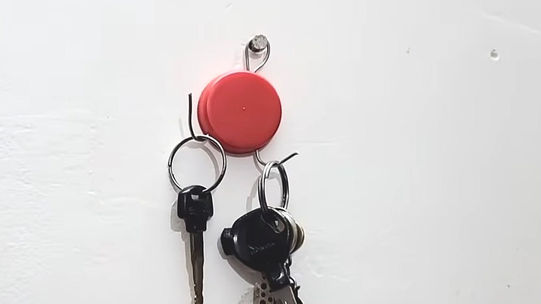 Closeup of a key holder made with a laundry detergent cap and some wire.