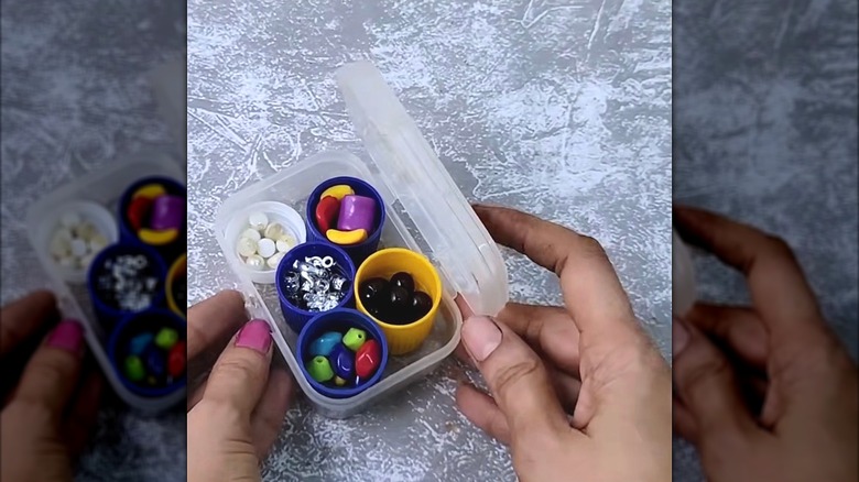 Detergent lids inside another container hold beads for crafting.