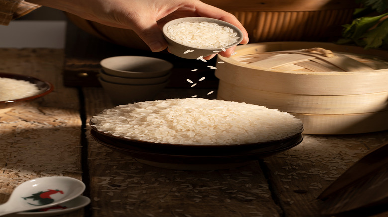 A woman holds a cap full of rice.