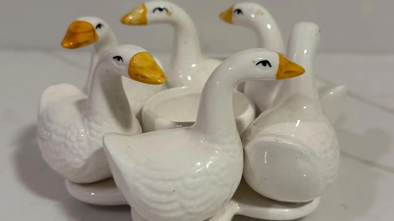 A ceramic candleholder featuring six hand-painted geese in a circle.