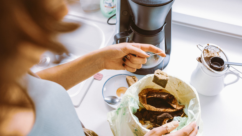 Woman putting tea bags in the compost in her kitchen