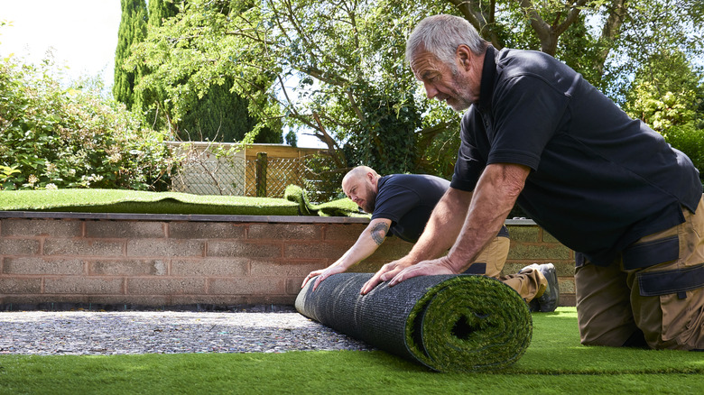 People installing artificial turf