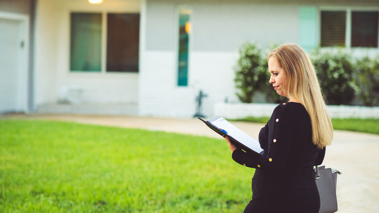 A person reading a document outside home