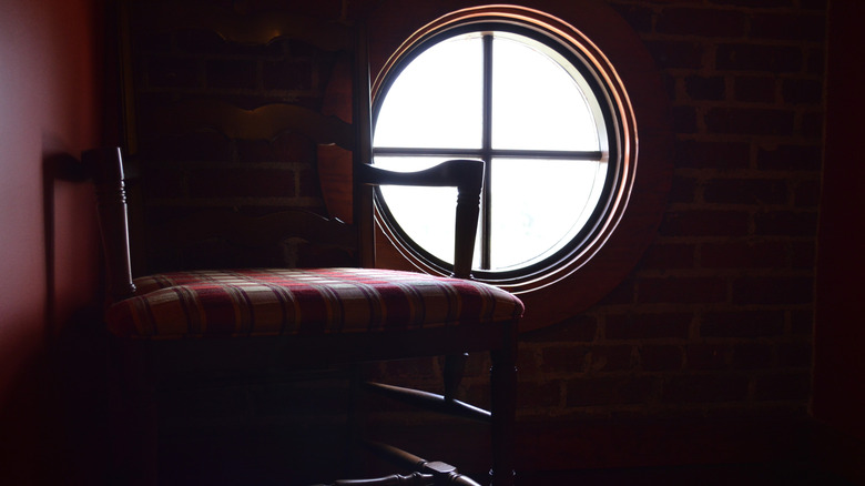 Vintage chair sitting next to round window