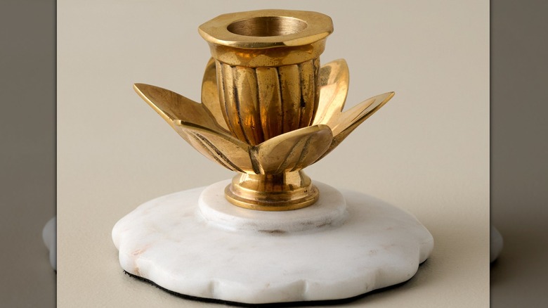 Brass flower-shaped candle holder with a marble base