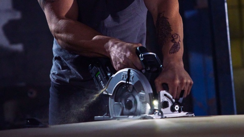 Man using Flex circular saw in piece of plywood